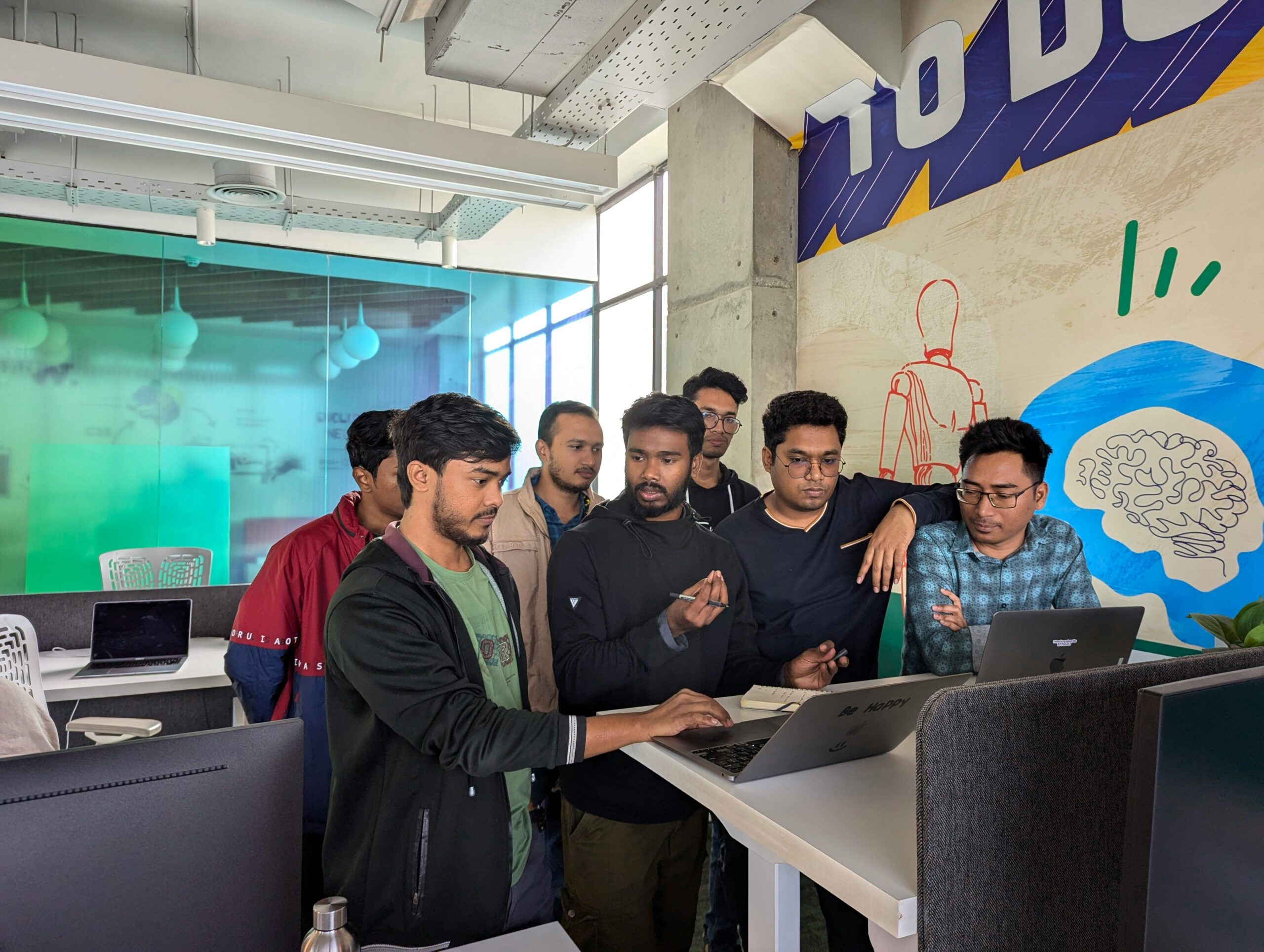 Team of professionals engaged in collaborative work at a vibrant modern office, showcasing teamwork and innovation.